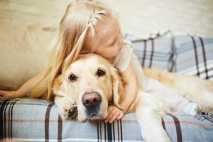 child laying on couch with dog