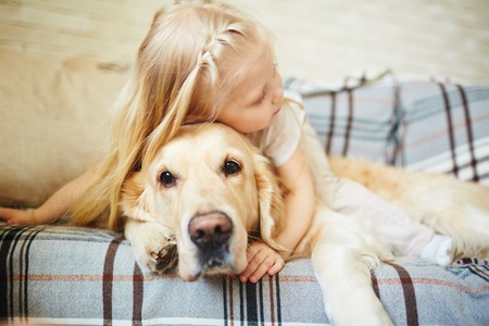 child laying on couch with senior dog